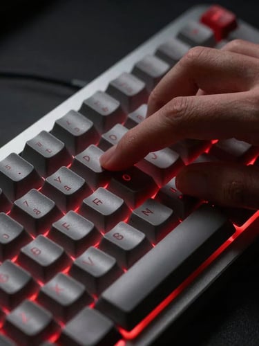Macro close-up of hands on a mechanical keyboard, high-contrast studio lighting, sharp red backlighting glow, clean minimalist composition, 35mm
