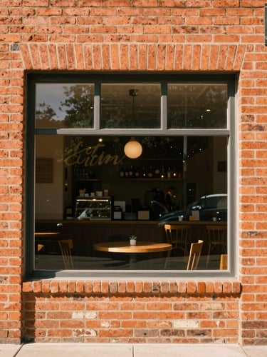 Warm environmental photograph of a local Austin cafe storefront, natural window light, terracotta brick facade, 35mm