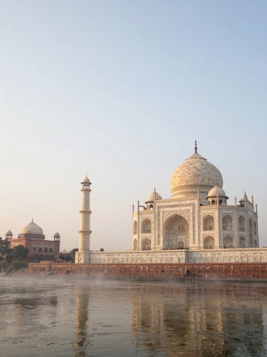 Wide panoramic view of the Taj Mahal at dawn from the eastern bank of the Yamuna river, mist rising off the water, monument placed in the right half of the frame, expansive pale sky above, no tourists in frame, golden sidelight catching the marble dome
