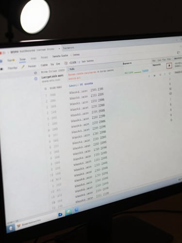 Extreme close-up of a computer monitor displaying blockchain transaction records with wallet addresses and transfer amounts, shot from slightly above in a darkened room with a single white studio strobe illuminating the screen, forensic detail visible, matte finish