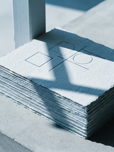 Minimalist corporate brand identity guidelines printed on heavy textured paper, cool blue tint, sharp architectural shadows, clean studio lighting