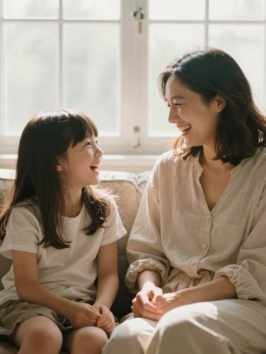 A mother and her school-aged daughter laughing together on a cozy sofa, soft morning window light, warm earth tones, 35mm