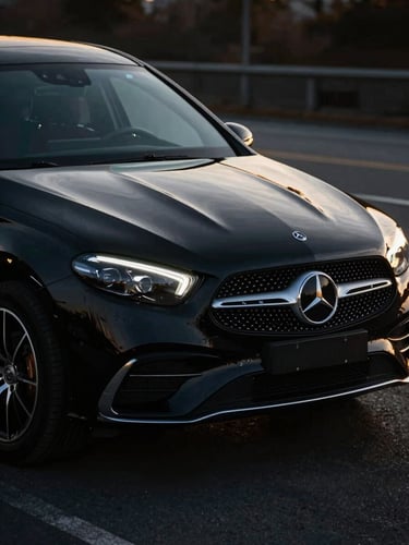 Mercedes-Benz aracın lüks deri iç mekanı, arkadan koltuk ısıtma düğmeleri ve ikramlıklar, sıcak ve davetkar ışıklandırma, 50mm, yüksek kontrastlı.