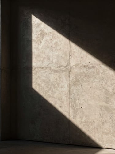 Dramatic architectural crop showing high-contrast light grazing a textured concrete wall, deep shadows, elegant editorial mood, 35mm lens
