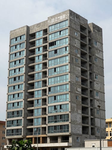 Close exterior shot of a completed Lagos residential block facade, even overcast daylight, concrete and glass detailing in sharp focus, street-level perspective showing the building's full ground floor and partial upper floors, no people, architectural precision