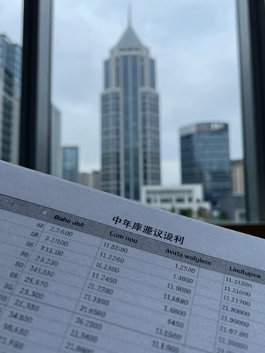 Cool editorial photography, sharp focus on macro details of a printed financial model spreadsheet with architectural lines of a modern financial district reflecting in the window background, muted blue and slate tones, soft overcast daylight, 35mm.