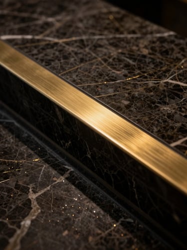 Extreme close-up of a flawless transition between dark veined marble and a hairline brushed brass inlay, dramatic low-key lighting, subtle metallic gold glints, 35mm architectural photography