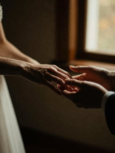 Moody wedding photography, close-up of hands gently touching, soft golden hour window light, rich textures, deep shadows, 35mm film grain
