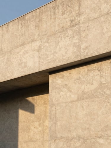 Minimalist concrete building facade with sharp geometric lines under soft golden hour light, architectural shadows, generous negative space