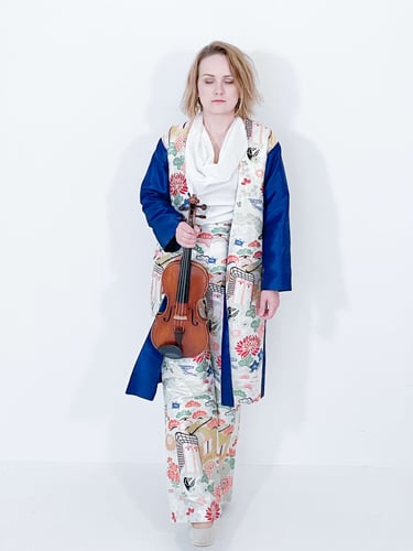 Portrait of Žydrė in traditional Japanese-inspired dress, eyes closed in contemplation while holding violin
