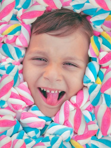 NIÑO SONRIENTE ENTRE BOMBONES