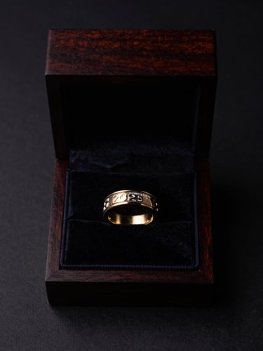 Minimalist overhead shot of an open, dark polished wooden presentation box, revealing a velvet-lined interior with a single 2026 FIFA World Cup Championship Ring resting inside, soft single-source lighting creating subtle shadows, deep obsidian and gold tones.