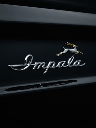 Dramatic close-up of a pristine chrome Chevrolet Impala emblem on a midnight black fender, sharp reflections, low-key studio lighting