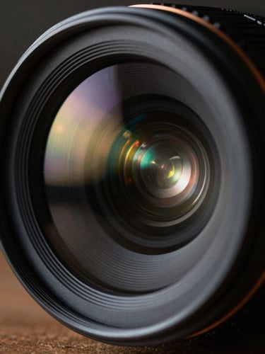 Extreme close-up of a high-end camera lens showing anamorphic flares and dramatic chiaroscuro reflections, cinematic film photography, 35mm