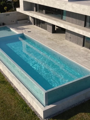 Wide architectural drone shot of a clean geometric infinity-edge pool integrated with a modern concrete villa at sunset, sharp shadows, high-contrast daylight