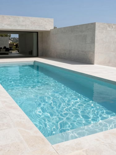 Wide architectural photograph of a minimalist zero-edge swimming pool integrated with a modern concrete villa, bright natural Mediterranean daylight, sharp geometric shadows, 35mm
