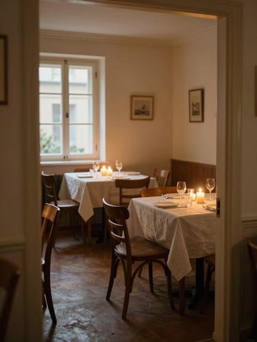 Warm dining room interior photographed from the doorway, amber candlelight on linen-covered tables, wooden chairs casting soft shadows, empty room before service, north-facing window glow on the far wall, intimate and unhurried
