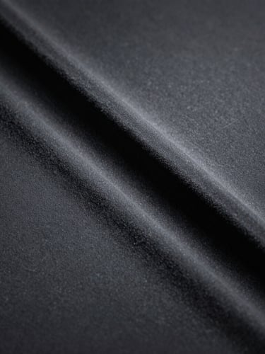 Extreme close-up macro shot of unbroken charcoal silicone texture, soft directional window light highlighting the velvet finish, deep shadows