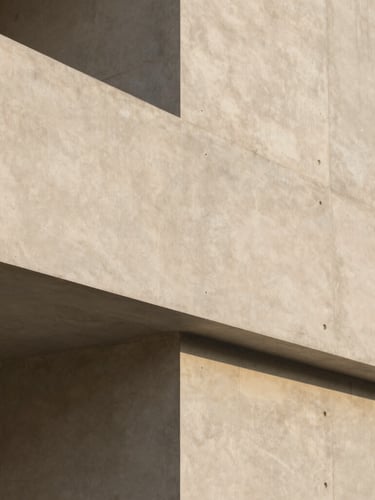 Architectural detail of a minimalist concrete building facade, clean geometric lines, soft diffused daylight, warm sand tones