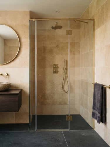 Architectural photograph of a luxury bathroom with a bespoke wetroom layout, warm stone tiling with millimeter-perfect alignment, brushed brassware, soft natural daylight, 35mm