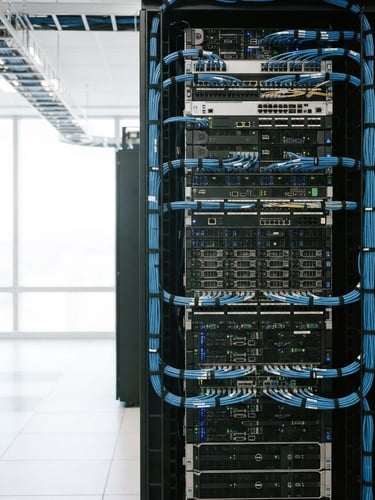 sharp, straight-on shot of an immaculate server rack with organized cable management, industrial blues and grays, bright clean daylight, 35mm, server rack filling right half of frame, wide aspect
