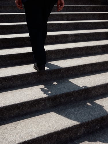 Direct harsh sunlight on a concrete staircase, shadow of a couple walking hand-in-hand cast long across the steps, high-contrast, medium-format film grain.