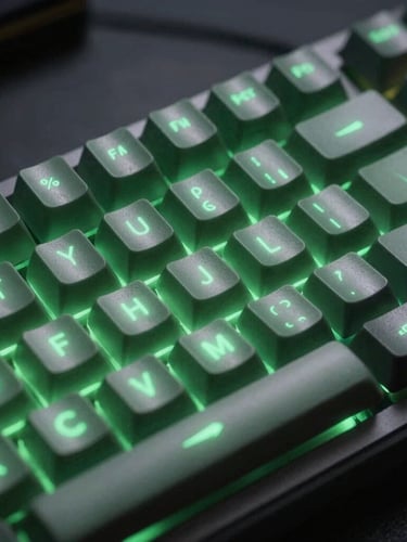 Macro close-up of a mechanical keyboard on a dark desk, glowing green status lights, sharp focus on keycaps, moody ambient studio lighting