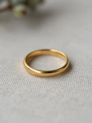 Macro shot of a delicate matte gold ring setting resting on textured linen, soft natural daylight, shallow depth of field