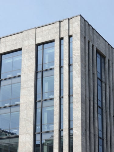 Clean corporate office building facade with sharp architectural lines, bright daylight, reflecting a high-trust professional atmosphere.