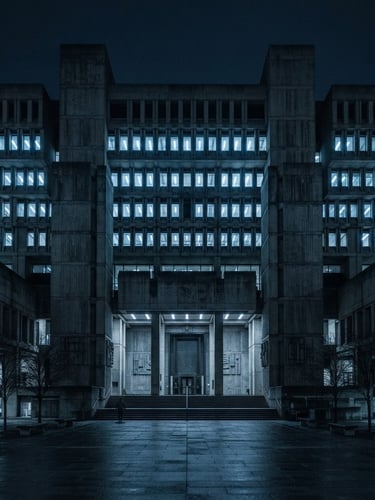 Wide symmetrical shot of a brutalist concrete government building exterior, cold blue fluorescent lighting, deep shadows, wide-angle, 35mm