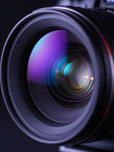 Macro close-up of high-end cinema camera lens edge-lit with glowing neon purple and electric blue lights in a dark production studio.