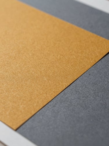 Macro crop of a vibrant amber and slate gray print proof under sharp studio lighting, highlighting the tactile paper grain.
