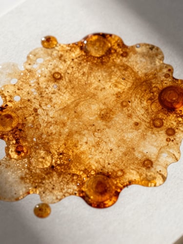 Macro crop of vibrant amber ink spreading across a textured heavy cardstock print proof, sharp directional studio lighting, deep shadows, high contrast.