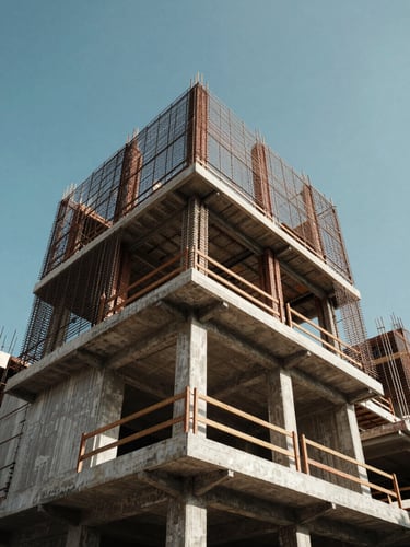 Góc nhìn từ dưới lên một ngôi nhà phố hiện đại tại TP.HCM đang hoàn thiện phần thô, khung bê tông cốt thép vững chắc dưới ánh nắng ban ngày, bầu trời xanh trong trẻo.