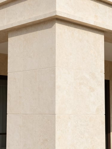 Close-up architectural photograph of natural limestone cladding joints on a luxury villa exterior at Al Reem Island, clean stone joints, bright natural daylight, sharp focus, 35mm