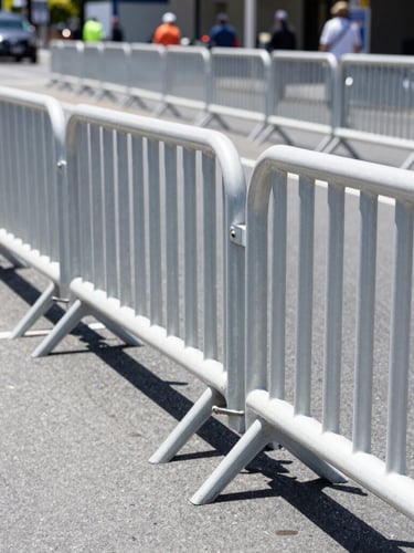 Crisp medium shot of interlocking steel pedestrian barriers deployed along a clean New Zealand street during a public event, bright natural daylight, 35mm lens.