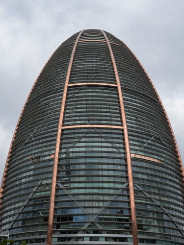 Dignified low-angle shot of the Baku terminal steel framework, dramatic overcast daylight, monumental scale, steel gray and copper accents.