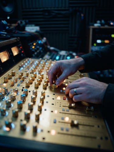 Close-up of hands adjusting dials on a high-end golden audio mixing console in a dimly lit studio, neon blue backlighting, shallow depth of field, 35mm