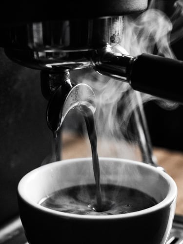 Tight macro shot of dark espresso extraction, steam rising against a dark, high-contrast background, 35mm lens, minimalist monochrome café photography, deep blacks, crisp whites.