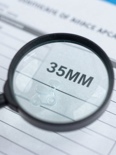 Macro close-up of a printed Certificate of Analysis document with a magnifying glass, sterile laboratory lighting, sharp focus, 35mm