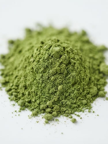 Macro close-up of vibrant green moringa powder on a clean white surface, bright diffused studio light, shallow depth of field, natural color