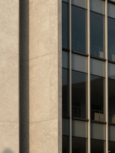 Minimalist architectural detail of concrete and glass facade, sharp straight lines, soft afternoon daylight with gentle shadows, 35mm warm editorial photography
