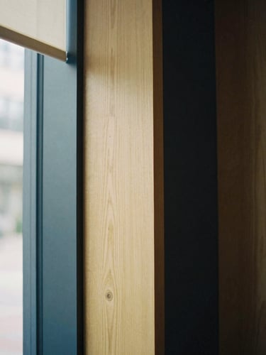 Architectural detail of a modern, quiet private banking office in Minnetonka, soft natural window light, warm oak wood and deep navy tones, shallow depth of field, editorial film photography, 35mm