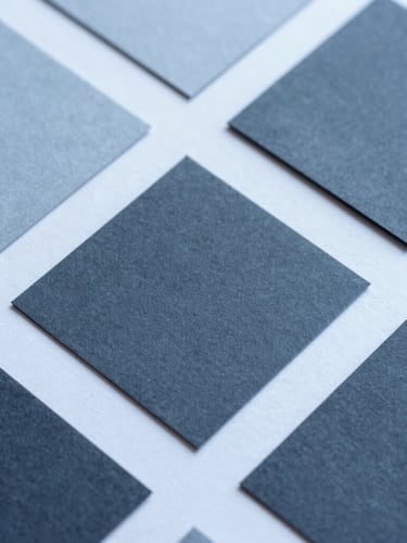 Close-up macro shot of physical design assets, textured paper mockups, clean geometric layouts, crisp studio lighting with cool blue undertones