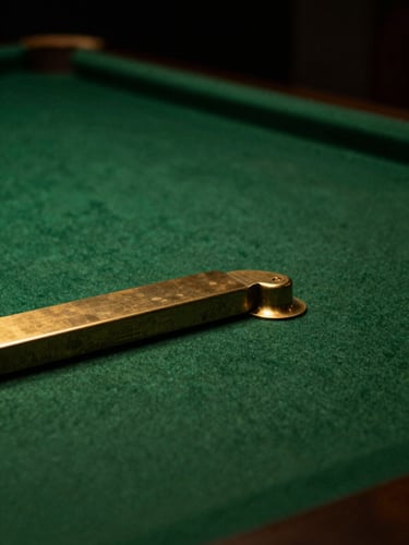 Dramatic close-up of a polished brass pocket corner on a forest green felt table, warm overhead lighting, shallow depth of field, moody editorial style.