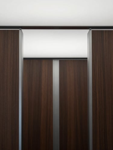 Close-up of a minimalist office interior, showing high-quality materials like dark wood and polished steel, soft architectural lighting, symmetrical framing, no people