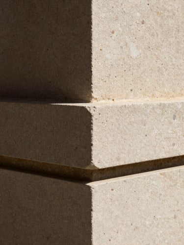 Extreme close-up of hand-carved local basalt stone joints under harsh tropical sunlight, deep shadows, rich tactile texture, 35mm lens architectural photography