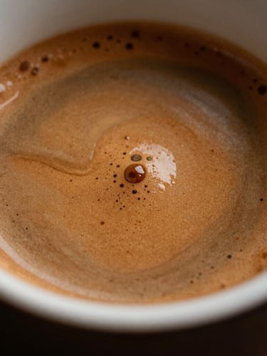 Macro close-up shot of rich espresso crema swirling in a dark ceramic cup, warm localized lighting highlighting the glossy texture and deep brown tones.