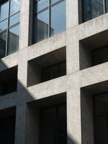 Geometric, high-contrast architectural detail of a concrete and glass office facade, stark sunlight casting clean diagonal shadows, minimalist composition.