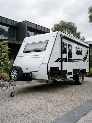 Low-angle heroic shot of a pristine caravan parked in a high-end Melbourne driveway, crisp overcast daylight reflecting off the polished gelcoat, 35mm automotive photography